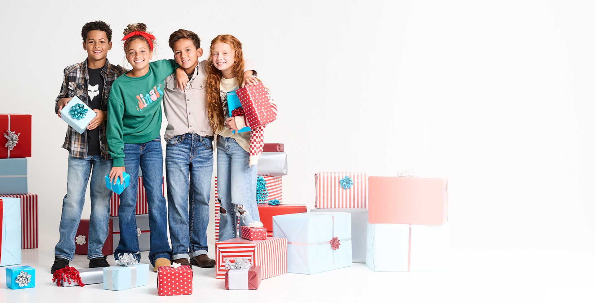 A group of 4 kids wearing the latest holiday styles from Buckle Kids.