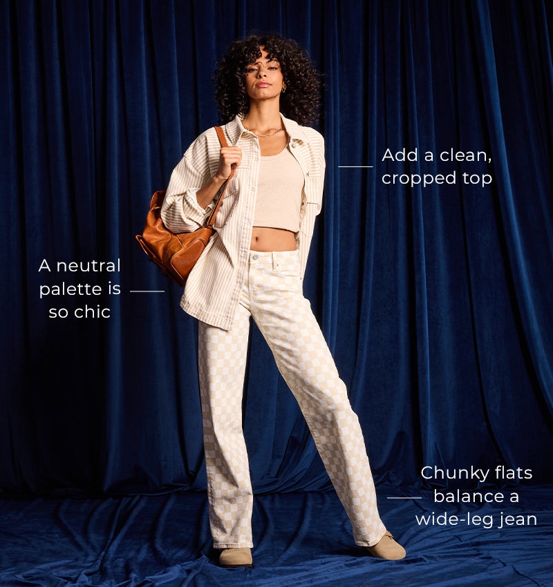 Get the Perfect Fit - A gal wearing a cream top under a cream button up shirt with a pair of printed jeans.